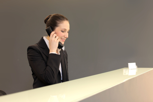 Receptionist of Naples Hotel Answering Guest's Call Using New Hotel Phone Systems