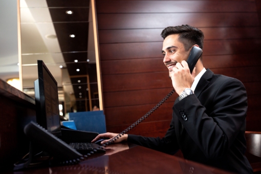 Receptionist of a West Palm Beach Hotel Answering Call via Newly Installed Hotel Phone Systems