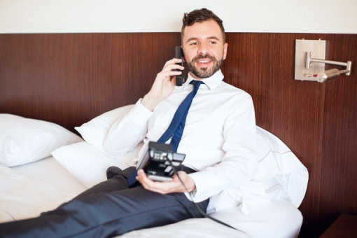 Gainesville Man On The Phone Using Newly Installed Phone Systems in His Hotel Room